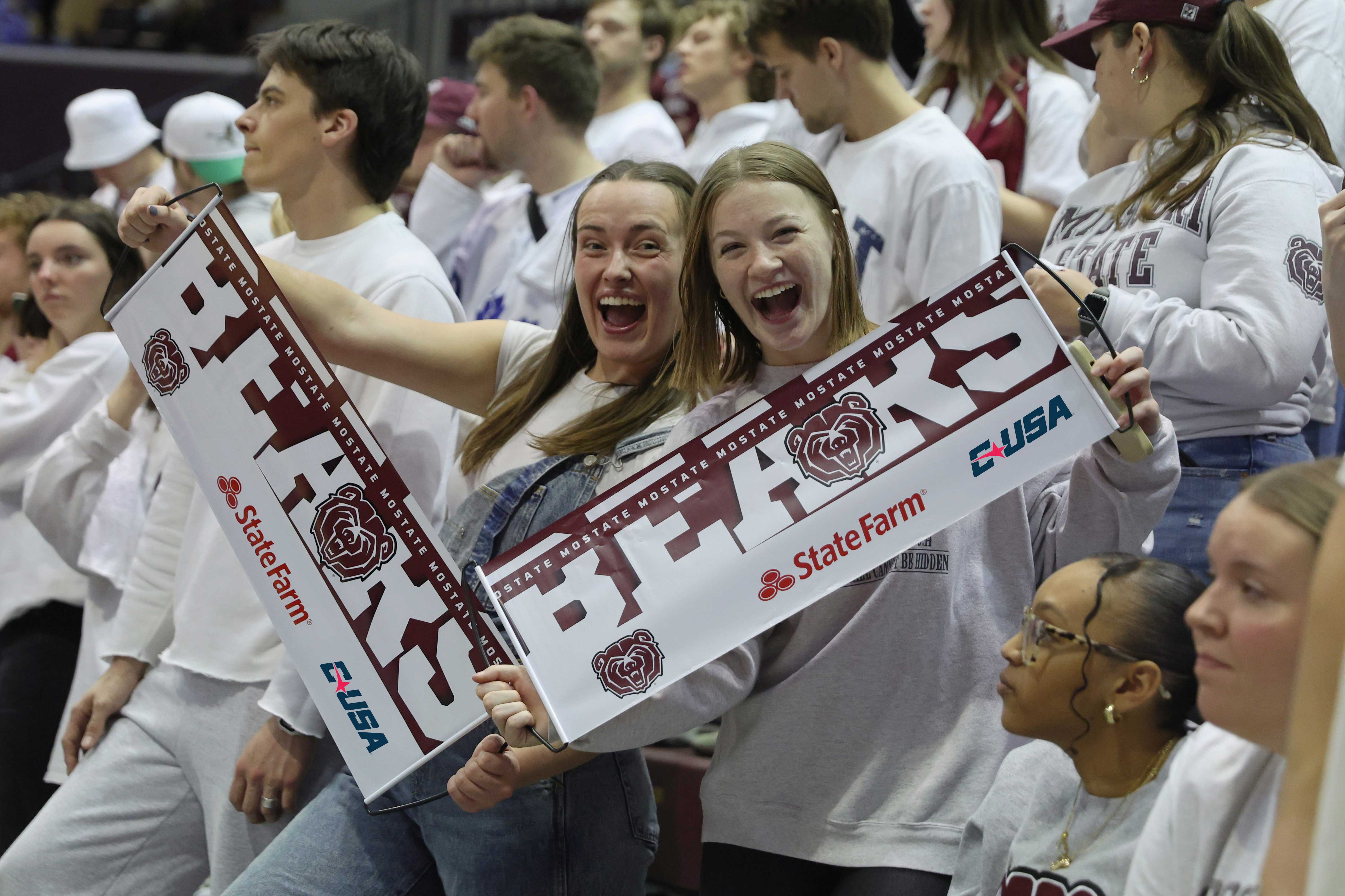 Two women holding Bears banner during sports game