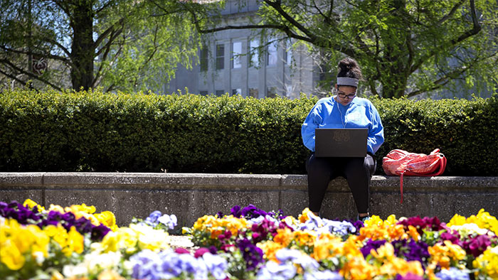 student on campus with laptop